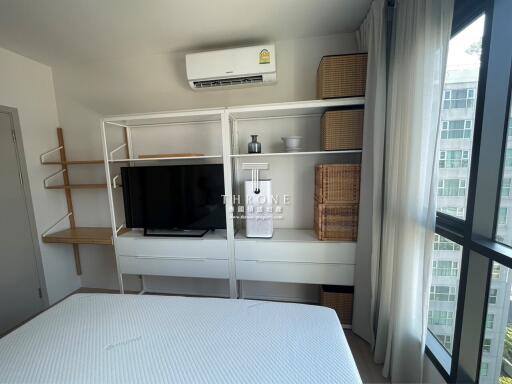 Modern bedroom with large bed, TV, and air conditioning unit
