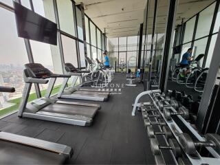 High-rise gym with panoramic city views featuring treadmills and exercise bikes