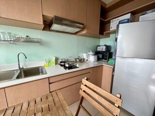 Compact kitchen with modern appliances and wooden cabinetry