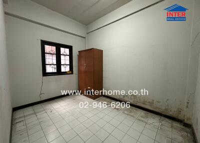 Empty bedroom with tiled floor and a wooden door