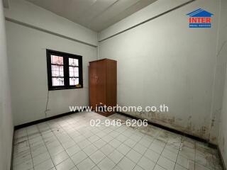 Empty bedroom with tiled floor and a wooden door