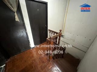 Interior staircase in a home with wooden banisters and tiled flooring