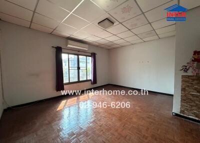 Spacious empty bedroom with large window and hardwood floors