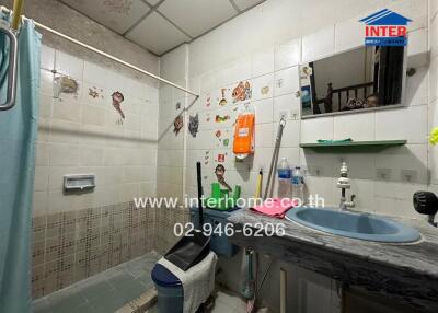 Spacious bathroom with wall-mounted storage units and tiled walls