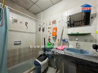 Spacious bathroom with wall-mounted storage units and tiled walls