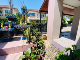 Well-maintained outdoor area of a residential property with a spiritual shrine and lush greenery