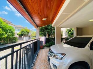 Elegant residential exterior with carport and lush greenery