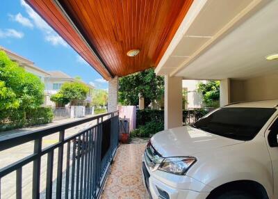 Elegant residential exterior with carport and lush greenery