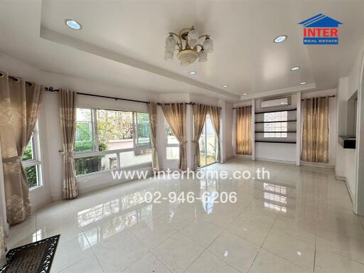 Spacious and bright living room with large windows and elegant curtains