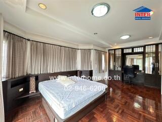 Spacious master bedroom with natural light and elegant wooden flooring