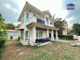 Exterior view of a two-storey residential house with balcony and garden