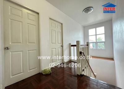 Bright and spacious hallway with polished wooden floors and crisp white walls