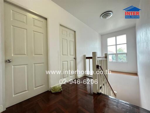 Bright and spacious hallway with polished wooden floors and crisp white walls