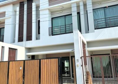 Modern two-storey townhouse with wooden gate