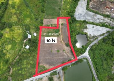 Aerial view of a large property lot outlined in red near natural surroundings