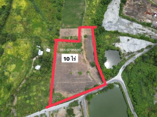Aerial view of a large property lot outlined in red near natural surroundings