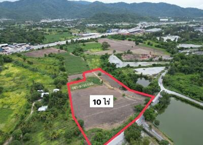 Aerial view of a spacious land plot available for sale surrounded by lush greenery and bodies of water
