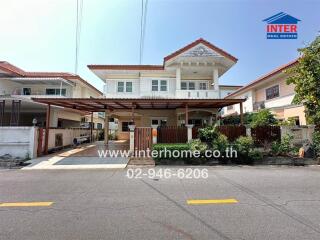 Suburban detached house with white facade and red roof including a carport