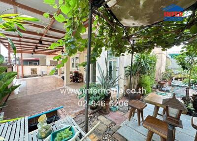 Spacious outdoor patio with roofing and lush greenery