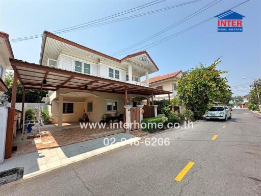 Spacious family home exterior with carport and comfortable seating area