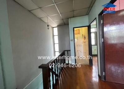 Spacious hallway with wooden flooring and natural lighting