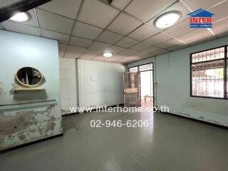 Spacious empty interior of a building with light blue walls and tiled flooring