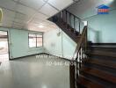 Spacious living area with wooden staircase and tiled flooring