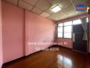 Spacious bedroom with pink walls and wooden flooring