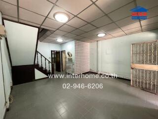 Empty spacious living area with staircase and decorative security bars