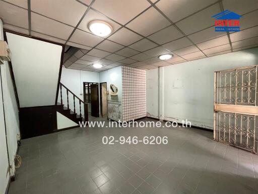 Empty spacious living area with staircase and decorative security bars