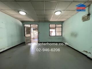 Spacious empty main living space with tiled flooring and two large windows