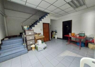 Spacious interior room with staircase and storage area