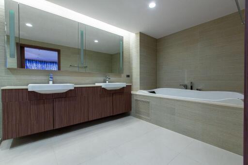 Spacious modern bathroom with dual vanities and a large tub