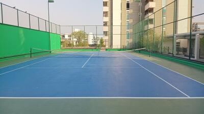 Well-maintained tennis court with surrounding residential buildings