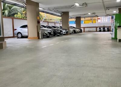 Spacious indoor parking garage with bright lighting and multiple parked cars