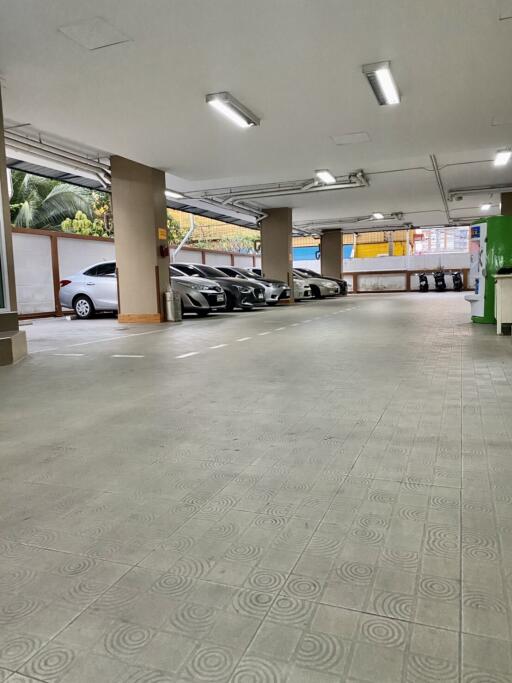 Spacious indoor parking garage with bright lighting and multiple parked cars