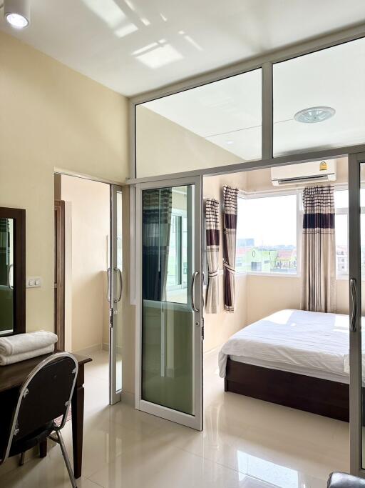 Spacious bedroom with large glass door leading to balcony