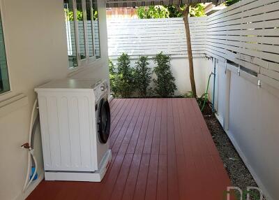 Well-maintained outdoor laundry space with washing machine and ample shelving