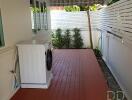 Well-maintained outdoor laundry space with washing machine and ample shelving