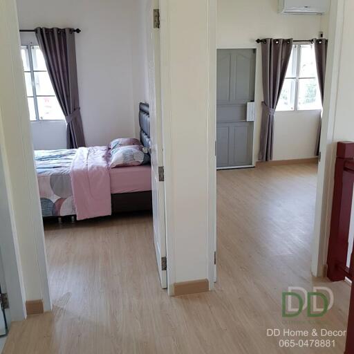 Spacious bedroom with open sliding doors and wooden flooring
