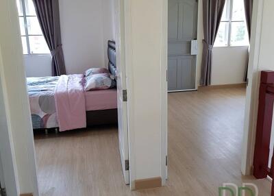 Spacious bedroom with open sliding doors and wooden flooring