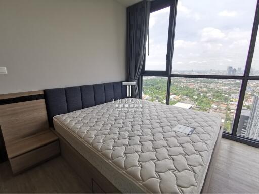 Modern bedroom with expansive city view through large windows