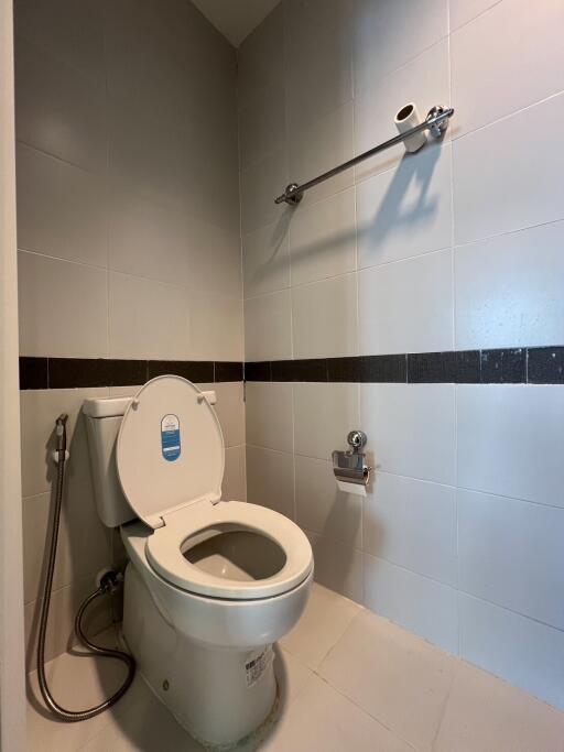 Modern bathroom with clean toilet and hand-held bidet sprayer