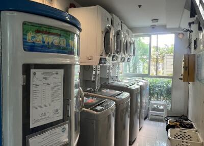 Well-equipped laundry room in apartment with multiple washers and dryers