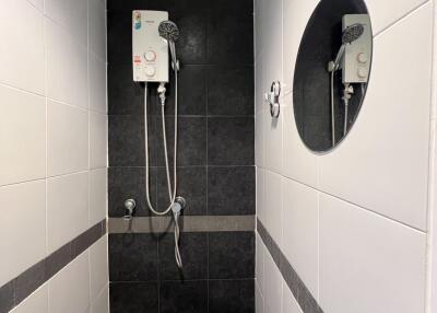 Modern bathroom with wall-mounted shower and stylish tiles