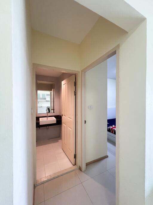 View of hallway leading to a kitchen and a bedroom