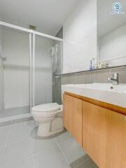 Modern bathroom interior with glass shower and wooden cabinetry