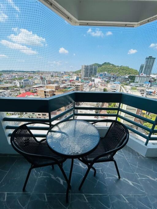 Spacious balcony overlooking the city with table and chairs