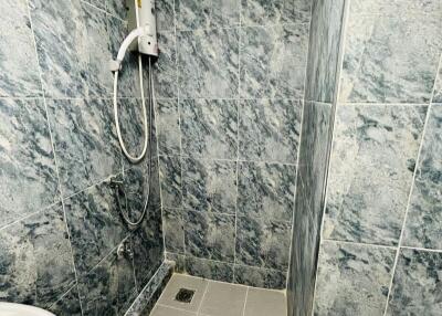Modern bathroom with wall-mounted shower and grey tiles
