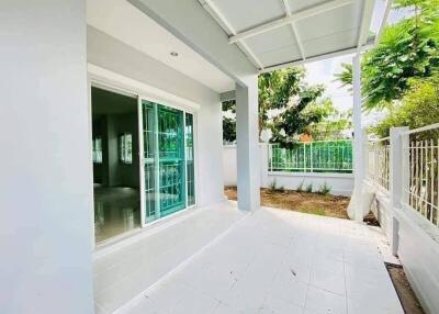 Spacious and bright porch area with white tiles and green window frames
